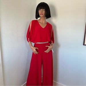Red slinky knit jumpsuit with rhinestone trim.